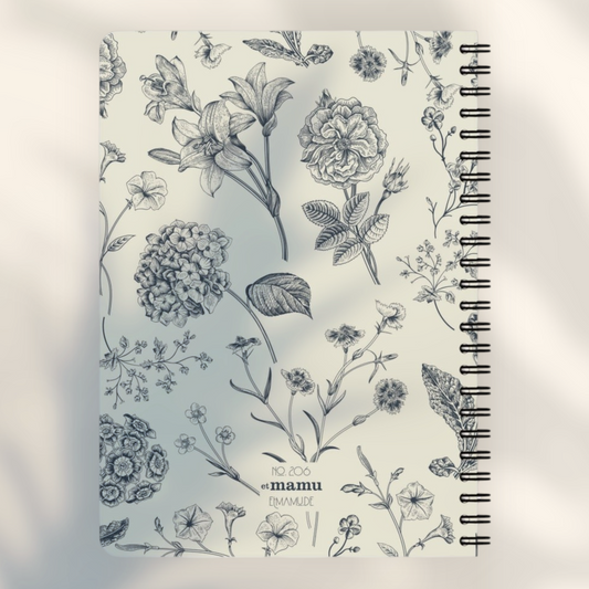 Eira Haul A5 spiral notepad with a cream cover featuring a detailed black botanical floral illustration pattern.