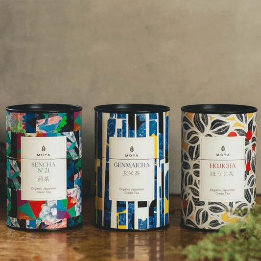 Three boxes of Japanese tea:sencha, genmaicha, and hojicha arranged on a table.