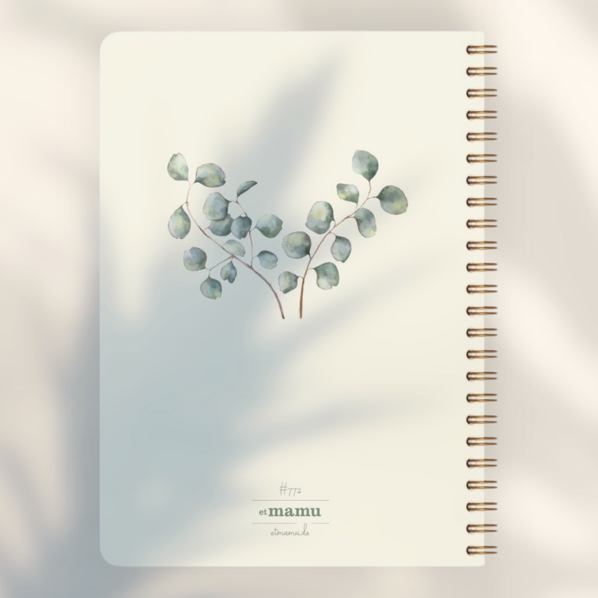 Eira Haul A5 notepad with cream cover, eucalyptus watercolor illustration, and black wire comb binding.