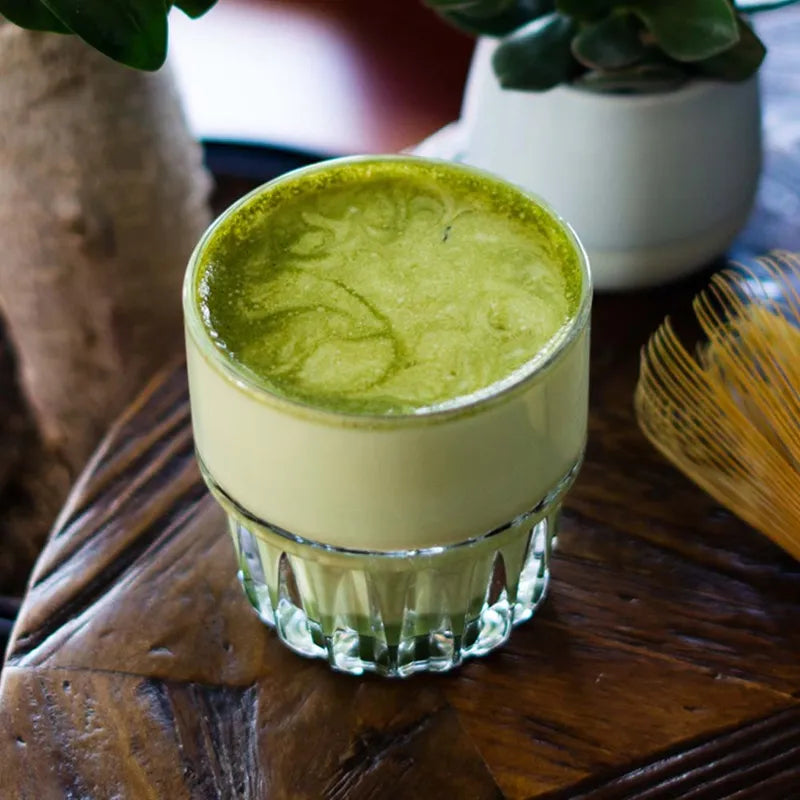 A matcha latte glass on a table.