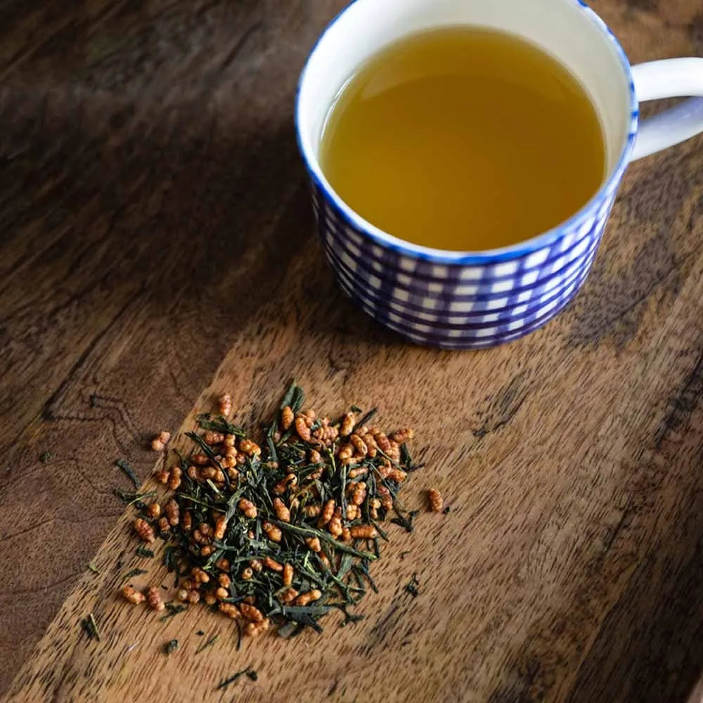 Moya organic Japanese genmaicha green tea with roasted rice without bag package next to a tea cup.