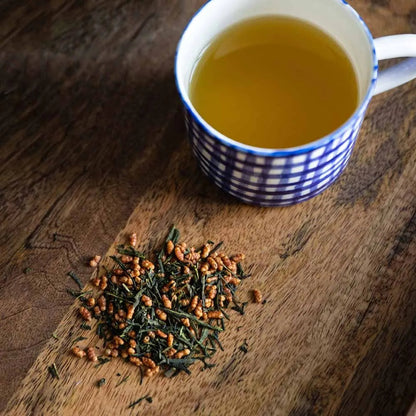 Moya organic Japanese genmaicha green tea with roasted rice without bag package next to a tea cup.