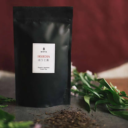 Moya organic Japanese hojicha green tea in an 80 g tea bag package with flowers.