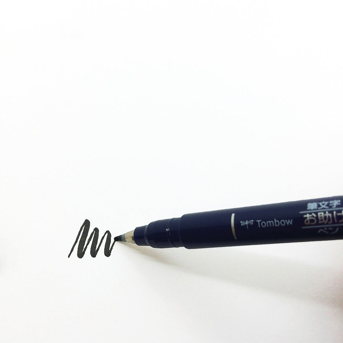 Eira Haul Tombow Fudenosuke black calligraphy brush pen with hard tip drawing a wavy line on white paper