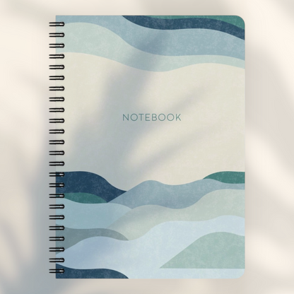 Eira Haul A5 notepad featuring an abstract geometric wave design in shades of blue, cream, and black wire binding.