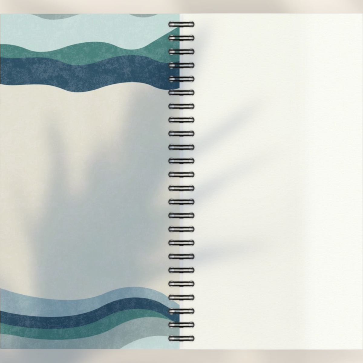 Eira Haul A5 notepad with abstract wavy blue and green geometric patterns, black wire binding, and rounded corners.