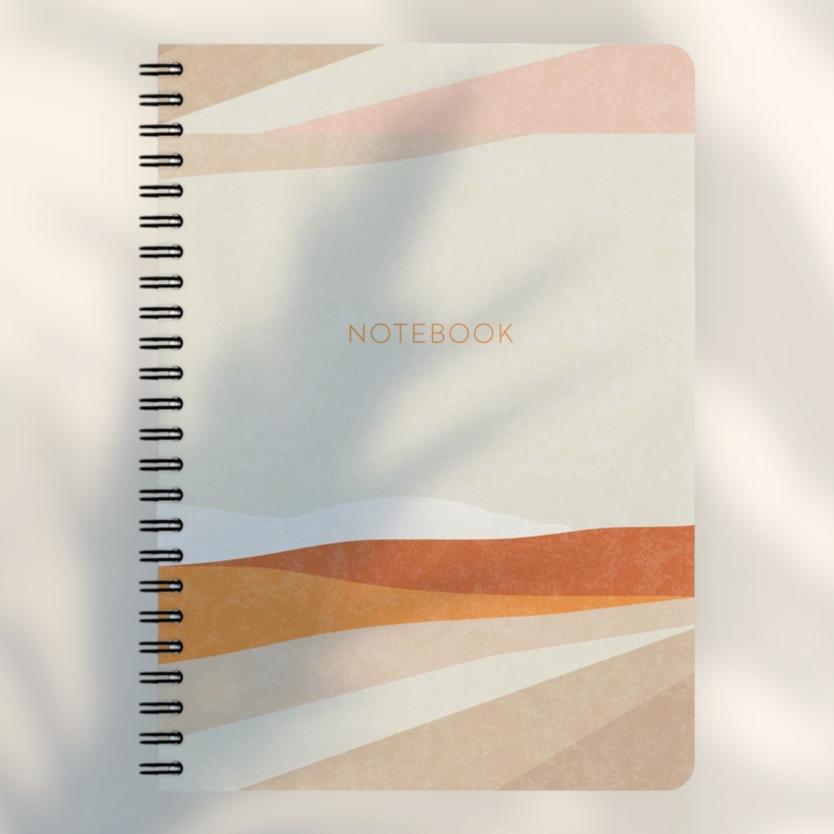 Eira Haul A5 notepad with abstract geometric shapes in warm earth tones, black wire binding, and rounded corners.