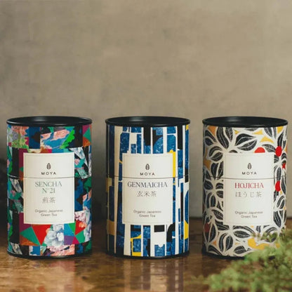Three boxes of Japanese tea:sencha, genmaicha, and hojicha arranged on a table.